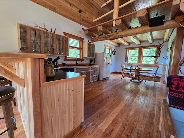 670GUSCREEK Gus Creek Rd, Yaak, MT 59935 - kitchen featuring freestanding refrigerator, hardwood / wood-style floors, dark countertops, and a wooden ceiling with exposed beams
