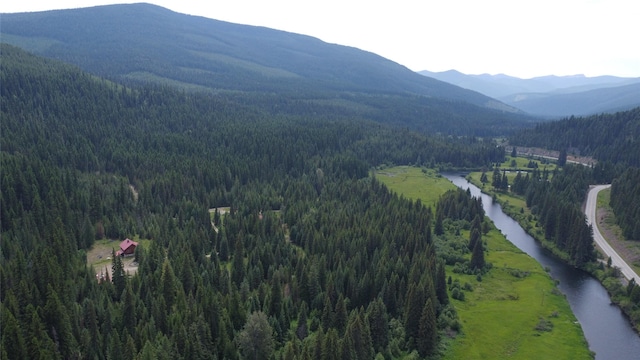 670GUSCREEK Gus Creek Rd, Yaak, MT 59935 - view of mountain backdrop featuring a heavily wooded area and a nearby body of water
