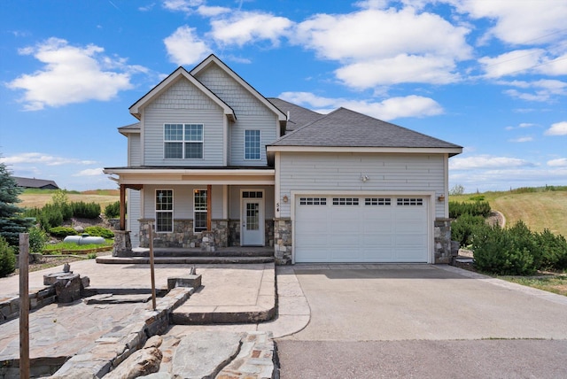 54 Bluebird Dr, Kalispell, MT 59901 - craftsman inspired home featuring stone siding, a porch, driveway, an attached garage, and a shingled roof