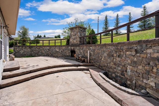 54 Bluebird Dr, Kalispell, MT 59901 - view of patio / terrace featuring an outdoor stone fireplace