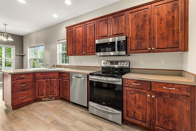 603 Luella Ln, Missoula, MT 59801 - kitchen with stainless steel appliances, a peninsula, light wood-style floors, recessed lighting, and light countertops