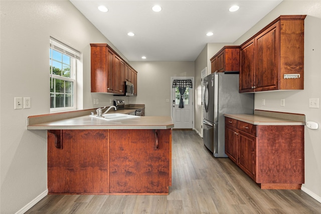 603 Luella Ln, Missoula, MT 59801 - kitchen featuring appliances with stainless steel finishes, light wood-style floors, a peninsula, recessed lighting, and light countertops