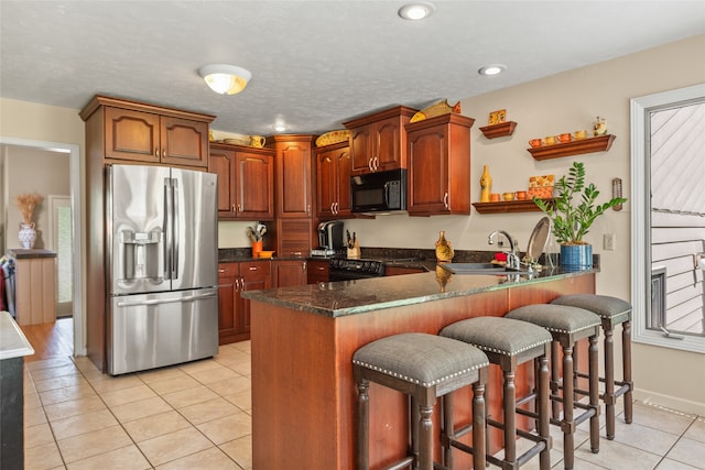 4280 Fox Farm Rd, Missoula, MT 59802 - kitchen with black appliances, open shelves, light tile patterned floors, a peninsula, and a breakfast bar area