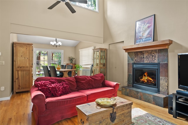 4280 Fox Farm Rd, Missoula, MT 59802 - living area featuring wood finished floors, a tiled fireplace, a chandelier, a ceiling fan, and a high ceiling