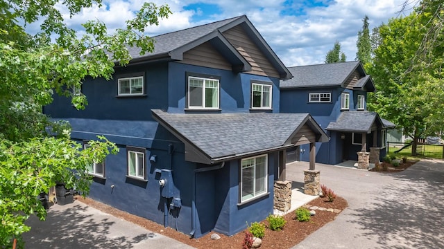 441 Karrow Ave, Whitefish, MT 59937 - craftsman house featuring stucco siding, concrete driveway, and roof with shingles