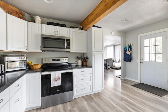 3265 US Highway 2 W, Kalispell, MT 59901 - kitchen with appliances with stainless steel finishes, beam ceiling, light wood finished floors, and white cabinets