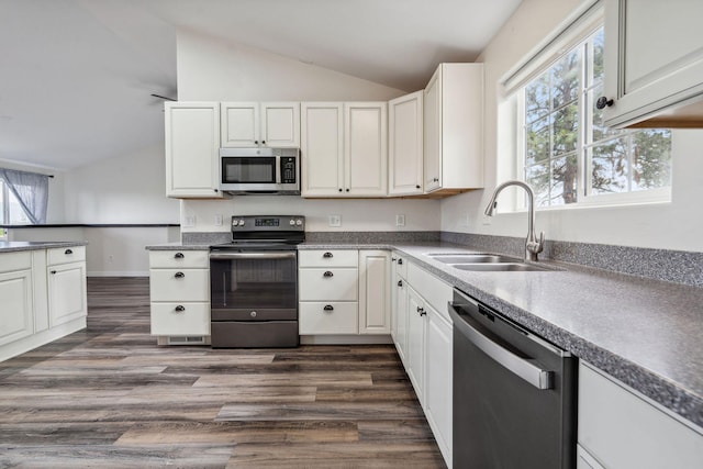 378 Last Best Pl, Kalispell, MT 59901 - kitchen featuring stainless steel appliances, lofted ceiling, dark wood-style flooring, and white cabinets