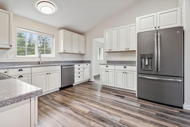378 Last Best Pl, Kalispell, MT 59901 - kitchen featuring stainless steel appliances, lofted ceiling, white cabinetry, and wood finished floors