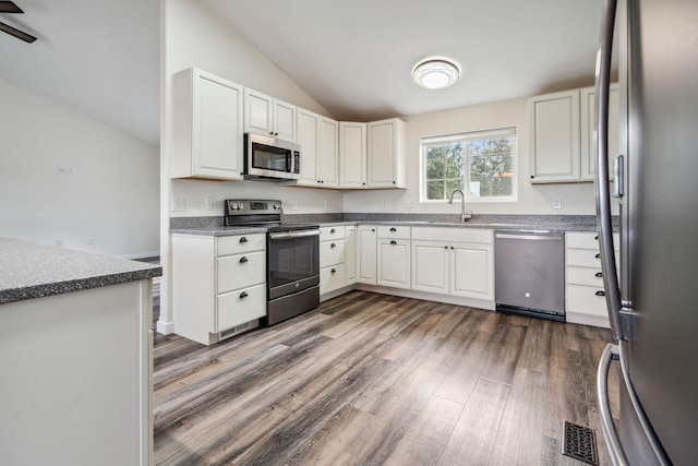 378 Last Best Pl, Kalispell, MT 59901 - kitchen featuring stainless steel appliances, vaulted ceiling, dark wood-type flooring, and white cabinets