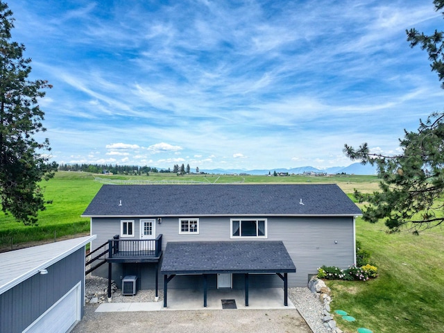 378 Last Best Pl, Kalispell, MT 59901 - rear view of house featuring a deck with mountain view, roof with shingles, and a patio area