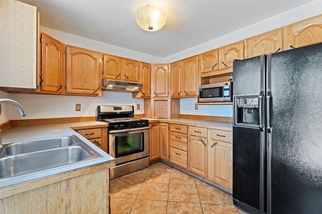 14470 Harpers Bridge Rd, Missoula, MT 59808 - kitchen with appliances with stainless steel finishes, under cabinet range hood, light countertops, and light tile patterned floors