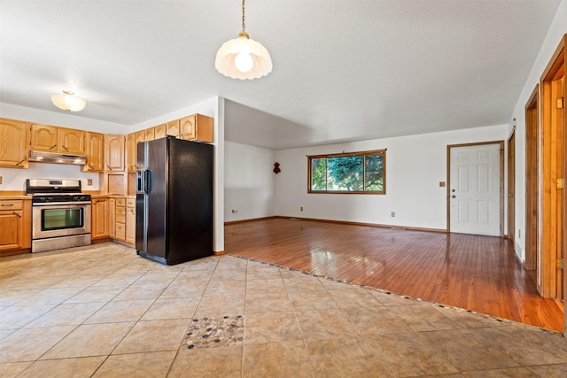 14470 Harpers Bridge Rd, Missoula, MT 59808 - kitchen with black refrigerator with ice dispenser, stainless steel gas range oven, under cabinet range hood, open floor plan, and light countertops