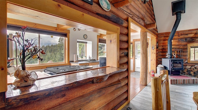 18998 Oris Ln, Florence, MT 59833 - kitchen featuring rustic walls, a wood stove, stainless steel gas stovetop, and hardwood / wood-style flooring