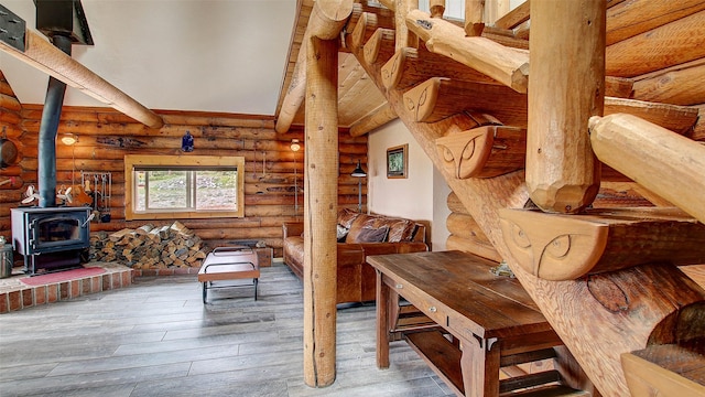 18998 Oris Ln, Florence, MT 59833 - dining space with rustic walls, a wood stove, wood finished floors, and beamed ceiling