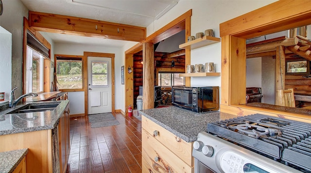 18998 Oris Ln, Florence, MT 59833 - kitchen with range with gas stovetop, open shelves, dark wood-type flooring, dark stone counters, and rustic walls