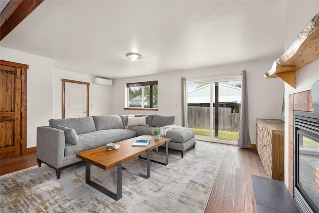 443 Karrow Ave, Whitefish, MT 59937 - living room featuring a wall unit AC, light wood finished floors, and a glass covered fireplace