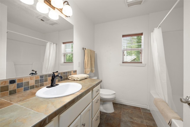 443 Karrow Ave, Whitefish, MT 59937 - bathroom featuring plenty of natural light, vanity, shower / bathtub combination with curtain, and stone finish flooring