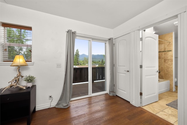 443 Karrow Ave, Whitefish, MT 59937 - bedroom with access to exterior, a mountain view, wood finished floors, and connected bathroom