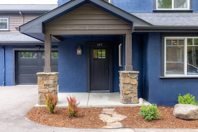 443 Karrow Ave, Whitefish, MT 59937 - view of exterior entry with roof with shingles, stucco siding, and a chimney