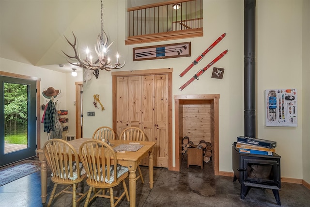 983 Lake Dr, Columbia Falls, MT 59912 - dining space featuring a chandelier, a towering ceiling, a wood stove, and concrete flooring