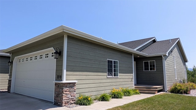 209 E Nicklaus Ave, Kalispell, MT 59901 - view of side of home featuring concrete driveway and roof with shingles