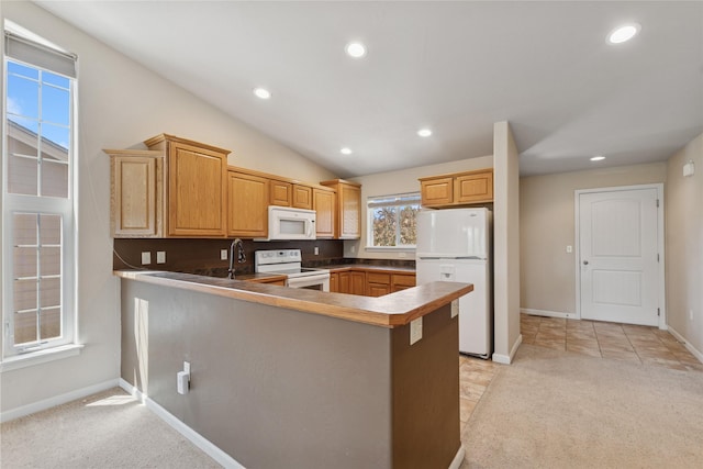 209 E Nicklaus Ave, Kalispell, MT 59901 - kitchen featuring white appliances, a peninsula, recessed lighting, light colored carpet, and lofted ceiling