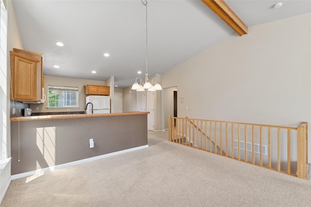 209 E Nicklaus Ave, Kalispell, MT 59901 - kitchen featuring light colored carpet, a chandelier, recessed lighting, a peninsula, and freestanding refrigerator