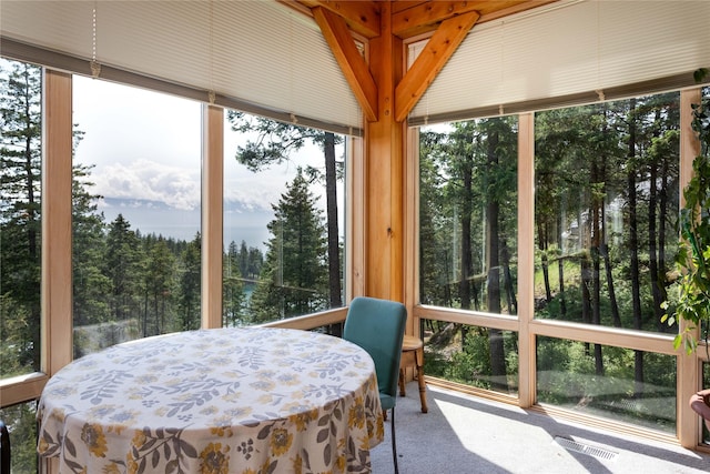 100 Deep Bay Dr, Lakeside, MT 59922 - sunroom / solarium featuring carpet flooring, plenty of natural light, and view of wooded area