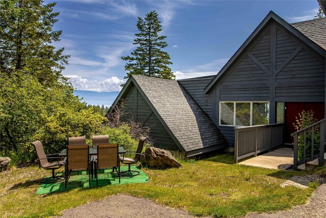 100 Deep Bay Dr, Lakeside, MT 59922 - view of home's exterior with a shingled roof, a lawn, and outdoor dining space
