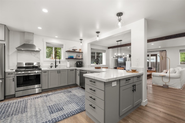 441/443 Karrow Ave, Whitefish, MT 59937 - kitchen with appliances with stainless steel finishes, gray cabinets, wall chimney range hood, light wood finished floors, and recessed lighting
