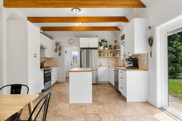 5014 Eastside Hwy, Stevensville, MT 59870 - kitchen with stainless steel appliances, a center island, tasteful backsplash, beamed ceiling, and open shelves