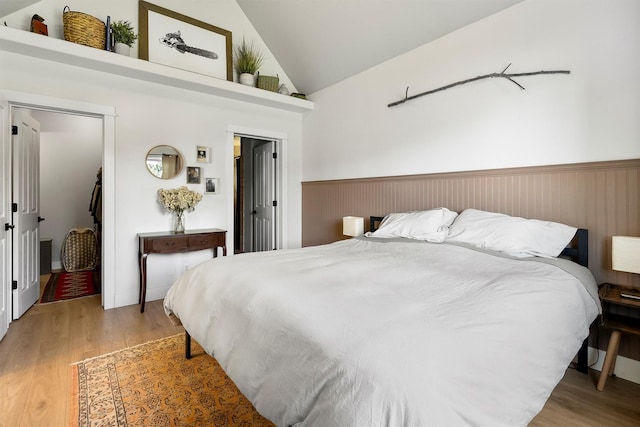 5014 Eastside Hwy, Stevensville, MT 59870 - bedroom with light wood-type flooring, vaulted ceiling, and wainscoting
