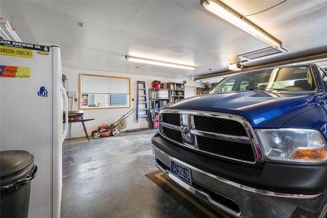 305 S Dell Dr, Havre, MT 59501 - garage featuring freestanding refrigerator and a garage door opener