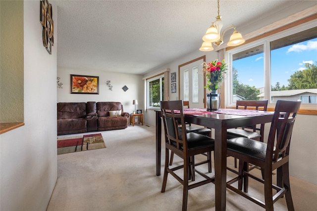 305 S Dell Dr, Havre, MT 59501 - dining room with a chandelier, a textured ceiling, and light colored carpet
