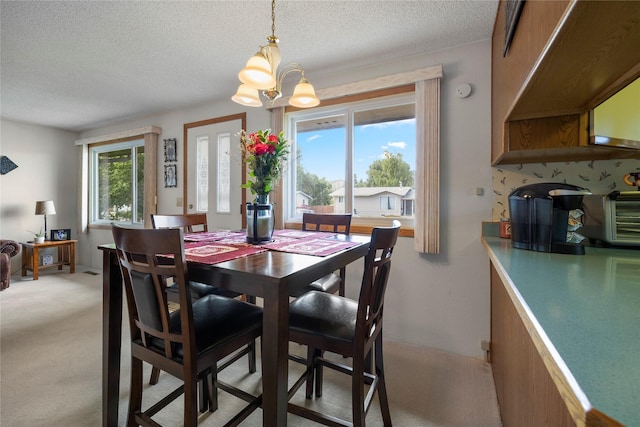 305 S Dell Dr, Havre, MT 59501 - dining area featuring a chandelier, a textured ceiling, and light colored carpet