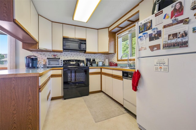 305 S Dell Dr, Havre, MT 59501 - kitchen featuring black appliances, decorative backsplash, white cabinets, and light countertops