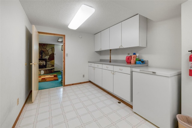 305 S Dell Dr, Havre, MT 59501 - kitchen with fridge, light flooring, light countertops, white cabinets, and a textured ceiling