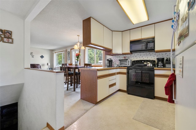 305 S Dell Dr, Havre, MT 59501 - kitchen featuring black appliances, a peninsula, light carpet, tasteful backsplash, and a chandelier