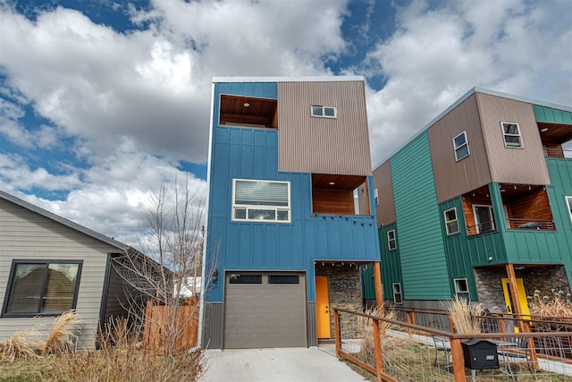 620 Phillips St Unit B, Missoula, MT 59802 - contemporary home with board and batten siding, an attached garage, a balcony, driveway, and stone siding