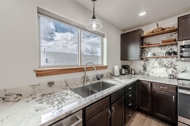 620 Phillips St Unit B, Missoula, MT 59802 - kitchen with stainless steel appliances, open shelves, light stone countertops, decorative light fixtures, and light wood-type flooring