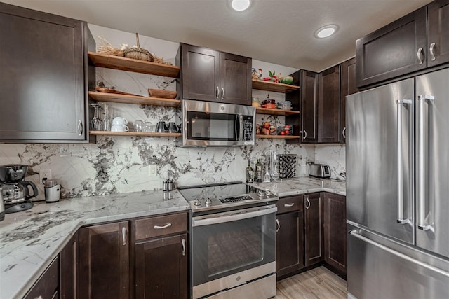 620 Phillips St Unit B, Missoula, MT 59802 - kitchen featuring appliances with stainless steel finishes, open shelves, dark brown cabinetry, tasteful backsplash, and light stone countertops