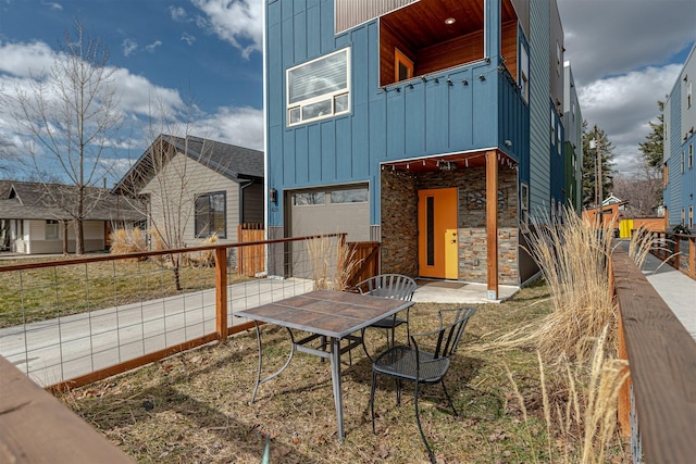 620 Phillips St Unit B, Missoula, MT 59802 - rear view of house with board and batten siding, a garage, and stone siding