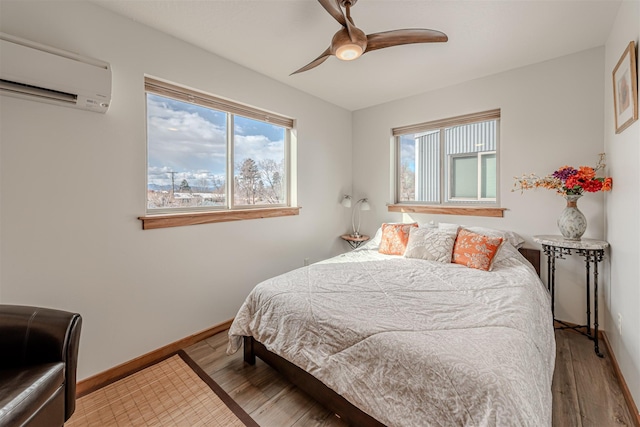 620 Phillips St Unit B, Missoula, MT 59802 - bedroom with a wall mounted air conditioner, wood finished floors, and ceiling fan
