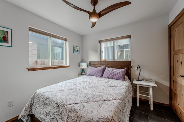620 Phillips St Unit B, Missoula, MT 59802 - bedroom with multiple windows, ceiling fan, and dark tile patterned flooring