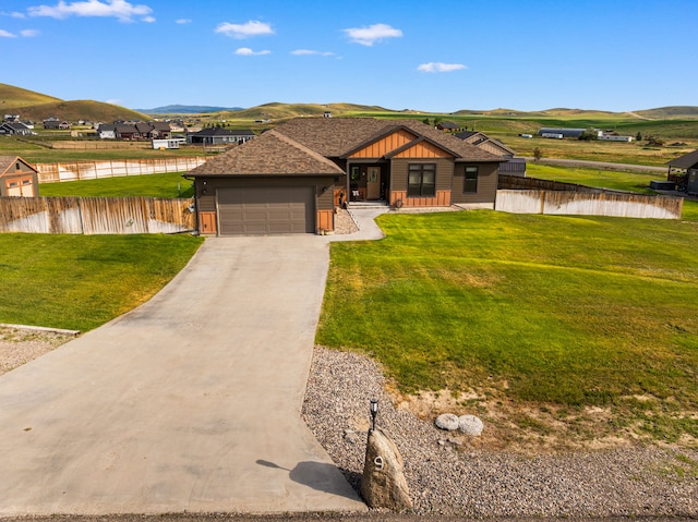 9 Blue Stem Way, Three Forks, MT 59752 - view of front of home with an attached garage, board and batten siding, a water and mountain view, and asphalt driveway