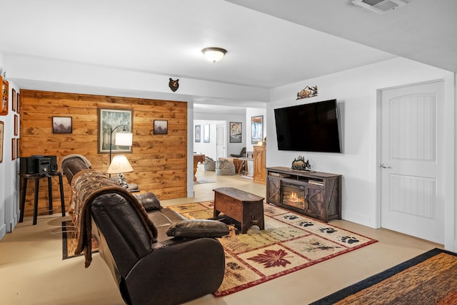 9 Blue Stem Way, Three Forks, MT 59752 - living room featuring wooden walls and a glass covered fireplace