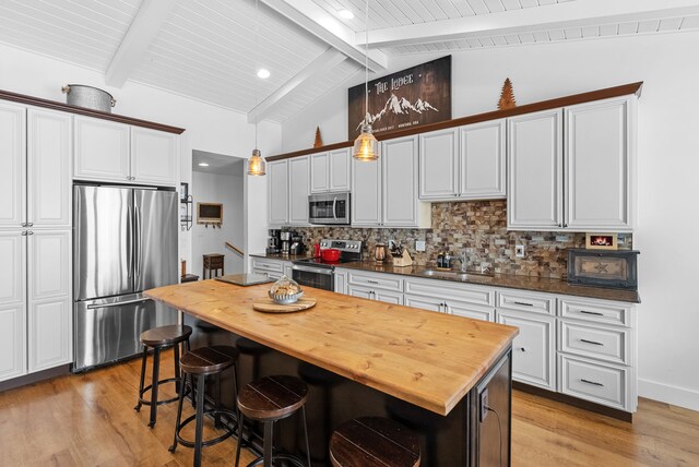 9 Blue Stem Way, Three Forks, MT 59752 - kitchen with stainless steel appliances, wooden counters, light wood-style floors, backsplash, and a kitchen island