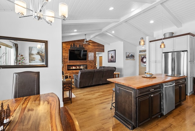 9 Blue Stem Way, Three Forks, MT 59752 - kitchen featuring butcher block countertops, light wood-style flooring, stainless steel appliances, a large fireplace, and a breakfast bar area