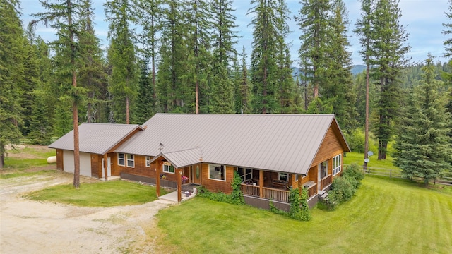 6611 Packer Creek Rd, Haugan, MT 59842 - view of front of house with dirt driveway, a view of trees, a garage, and covered porch