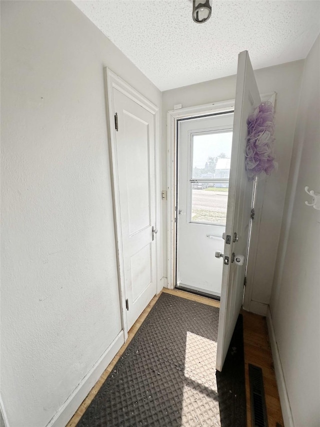 214 2nd Ave SW, Cut Bank, MT 59427 - doorway to outside with wood finished floors and a textured ceiling